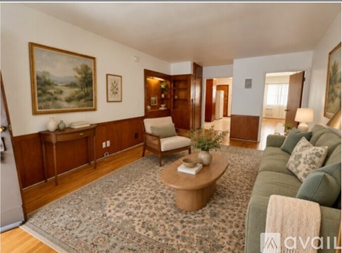 A living room with a couch, chair, and rug.
