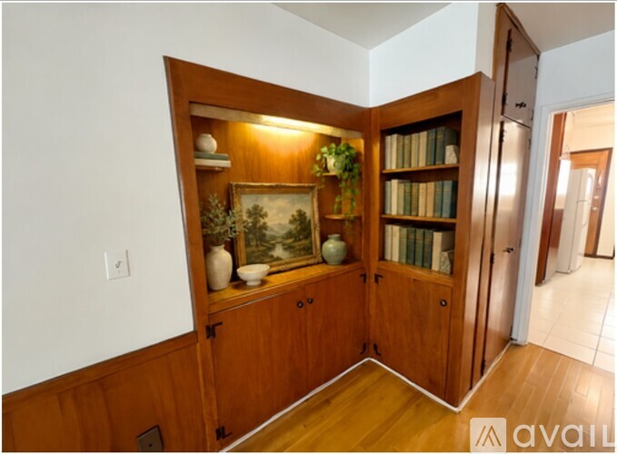 A room with a wooden cabinet and a painting on it.