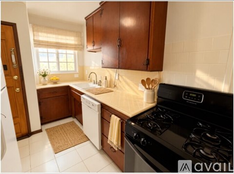 A kitchen with a black stove top oven and white dishwasher.