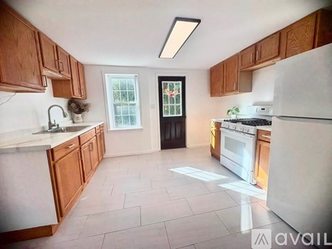 A kitchen with wooden cabinets and a white refrigerator.