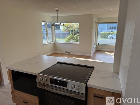 A kitchen with a stove top oven and a window.