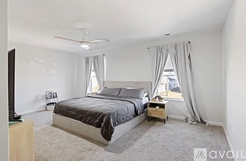 A bedroom with a large bed and a television on a wooden stand.