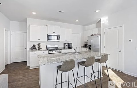 A kitchen with white cabinets and a marble countertop.