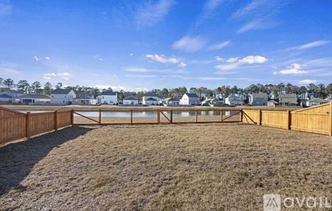 A backyard with a wooden fence and a grassy area.