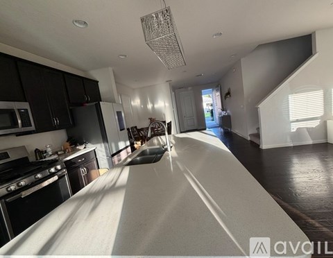 A modern kitchen with black cabinets and stainless steel appliances.
