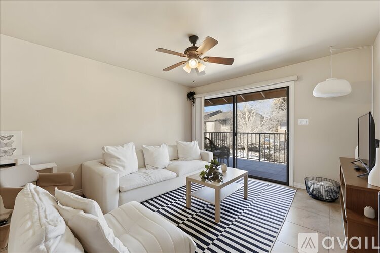 A living room with a white couch and a ceiling fan.