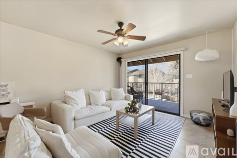 A living room with a white couch and a ceiling fan.
