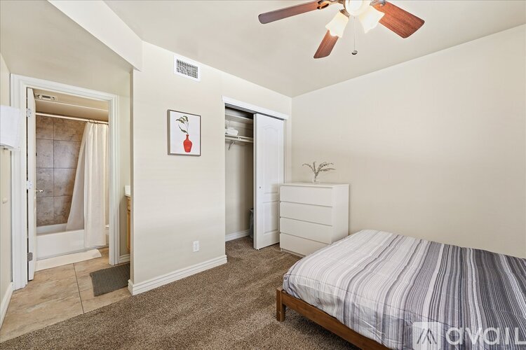 A bedroom with a bed, dresser, and window.