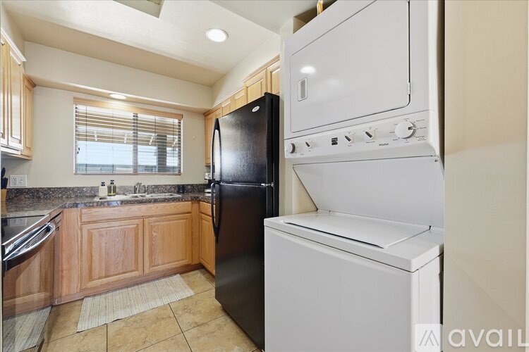 A kitchen with a black refrigerator and white oven.