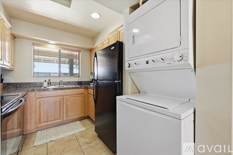 A kitchen with a black refrigerator and white oven.