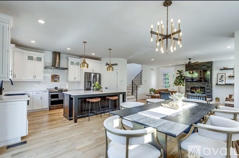 A modern kitchen with a large island and a dining table set for four.