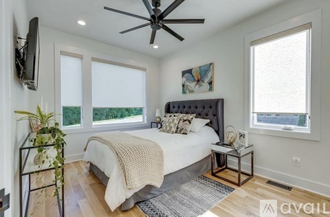 A bedroom with a large bed and a ceiling fan.