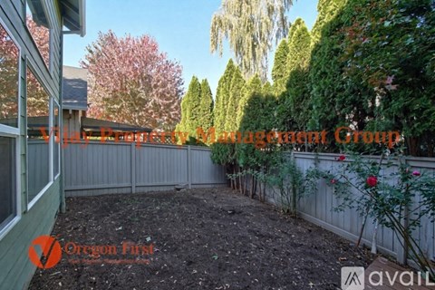A backyard with a fence and trees.