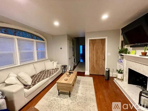 A living room with a couch, coffee table, and fireplace.