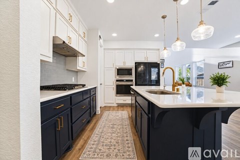 A kitchen with black cabinets and a white countertop.