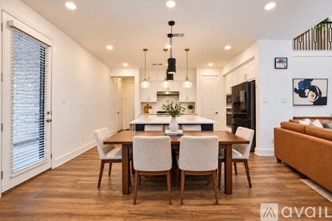 A modern dining room with a wooden table and chairs.