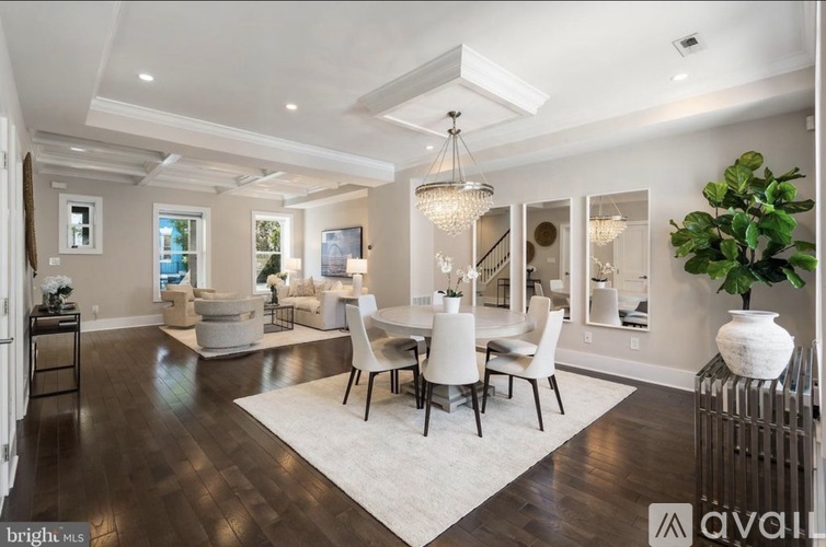 A spacious dining room with a large table and chairs.