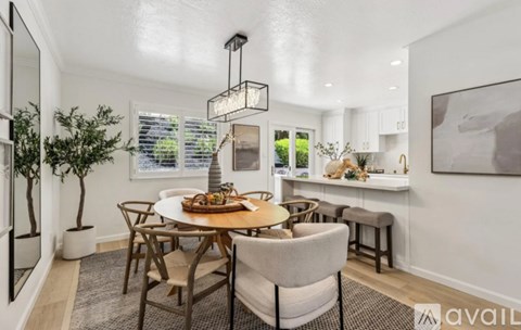 A dining room with a round table and chairs.