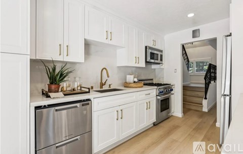 A kitchen with white cabinets and stainless steel appliances.