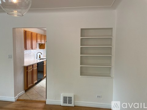 A kitchen with wooden cabinets and a white wall.