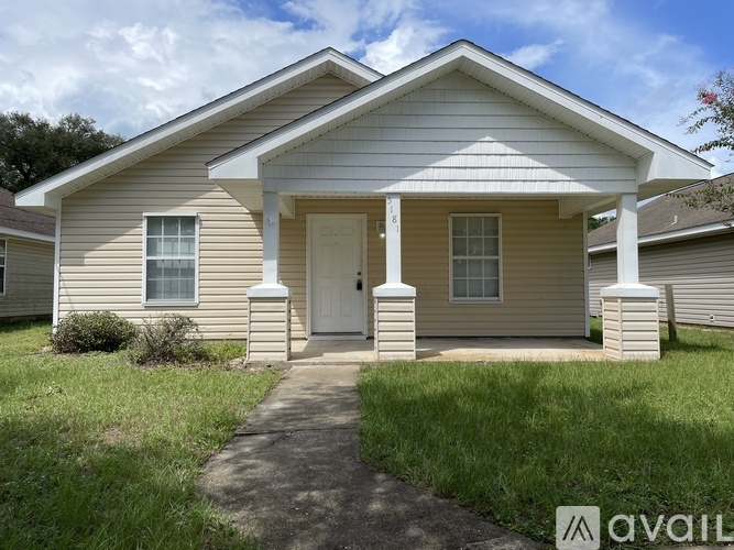 A beige house with a white door and pillars.