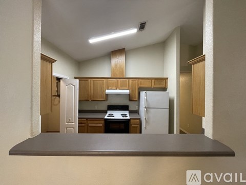 A kitchen with wooden cabinets and a white refrigerator.