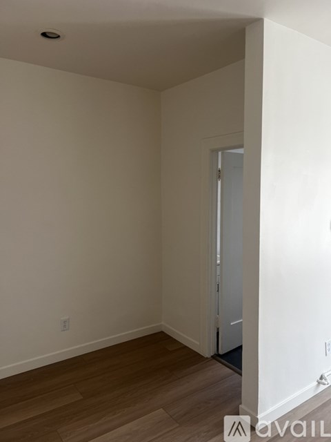 A room with wooden flooring and white walls.