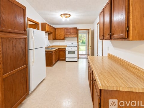 A kitchen with wooden cabinets and a white refrigerator.