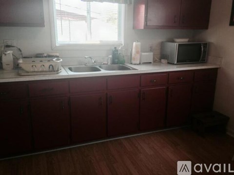 A kitchen with red cabinets and a white countertop.