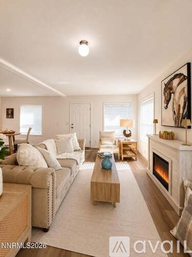A living room with a fireplace and a painting on the wall.