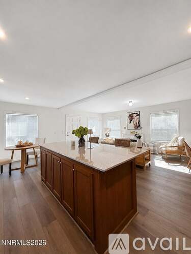 A spacious kitchen with wooden cabinets and a marble countertop.