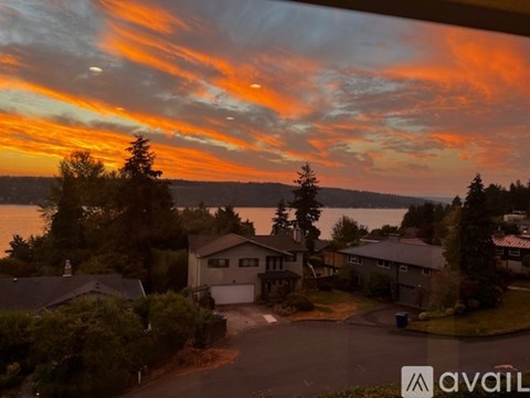 A beautiful sunset over a residential neighborhood with houses and trees.