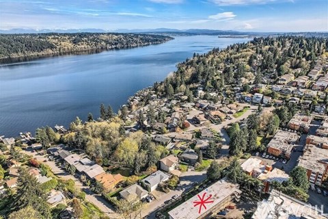 A red star is superimposed on a picture of a town by a lake.
