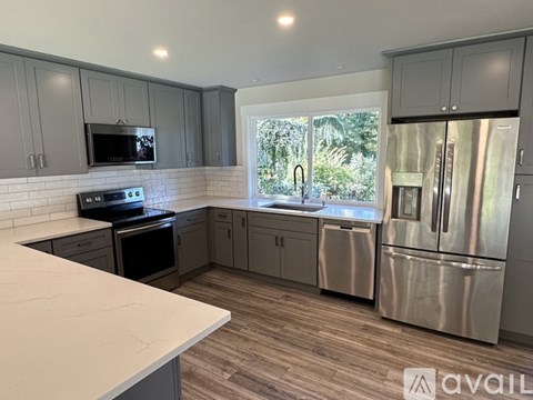 A kitchen with a refrigerator, stove, and microwave.