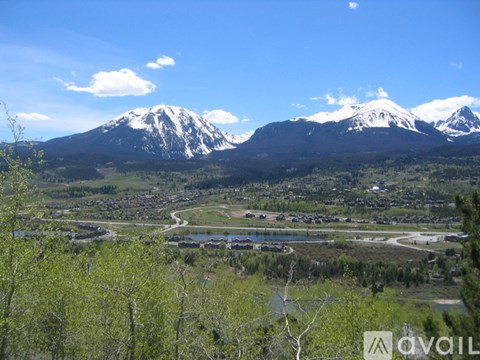 A mountain range with snow capped peaks in the background and a town in the foreground.