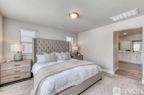 A bedroom with a large bed, a dresser, and a mirror.