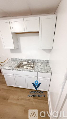 A kitchen with a granite countertop and white cabinets.