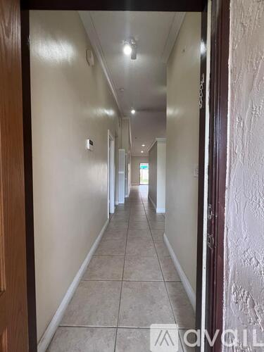 A long hallway with a door on the right.
