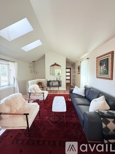 A living room with a red carpet and a skylight.