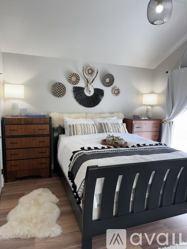 A bedroom with a large bed and a white furry rug.