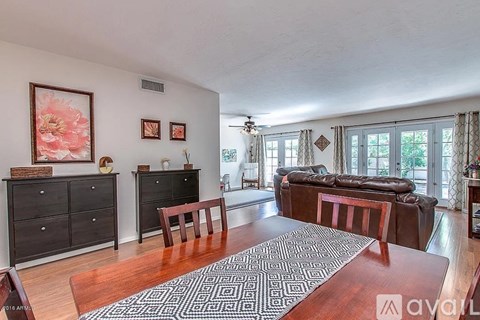 A living room with a brown rug and a brown table.