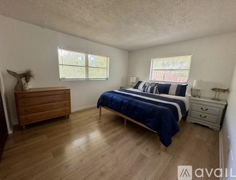 A bedroom with a bed, dresser, and window.