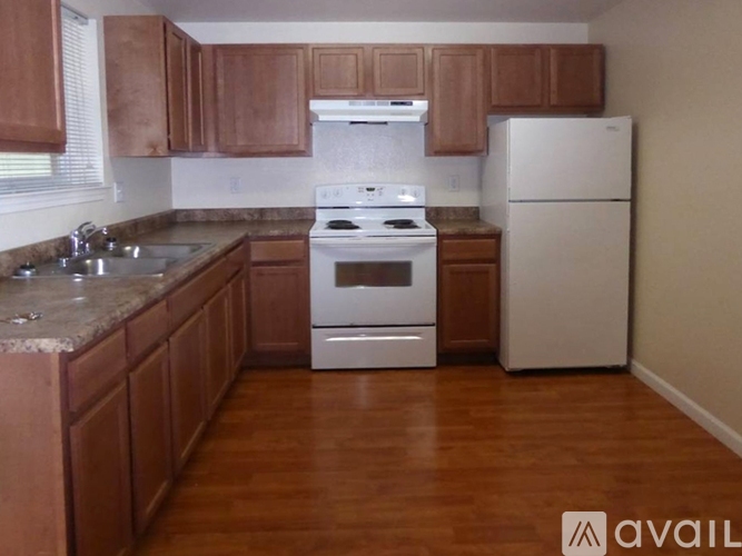 A kitchen with wooden cabinets and a white stove top oven.