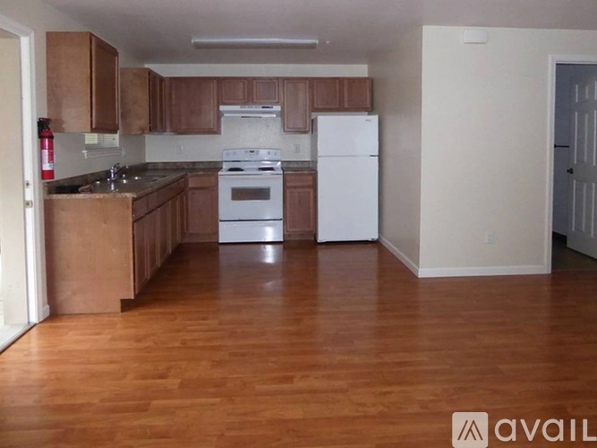 A kitchen with wooden cabinets and a white fridge.