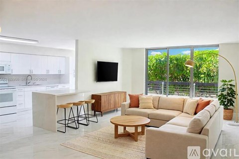 A modern living room with a large window and a flat screen TV mounted on the wall.