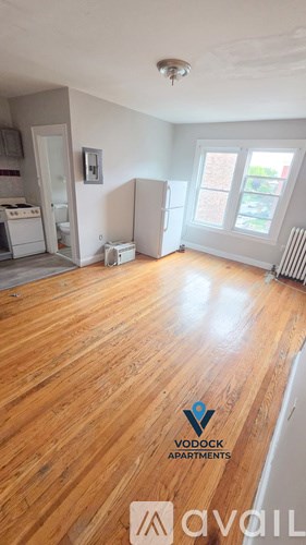 A Vodock Apartments living room with hardwood floors and a window.