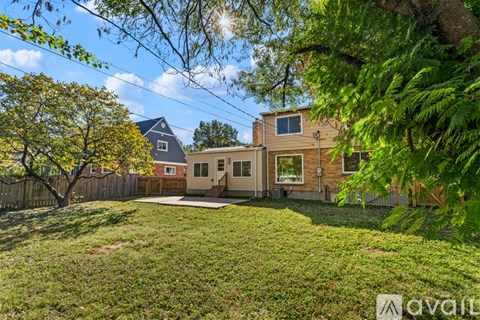 A house with a fence and trees in the front yard.