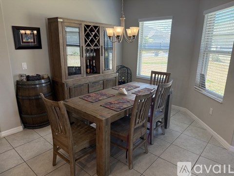 A dining room with a wooden table and chairs.