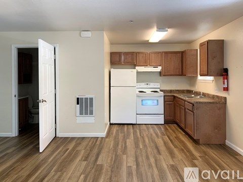A kitchen with wooden floors and white appliances.