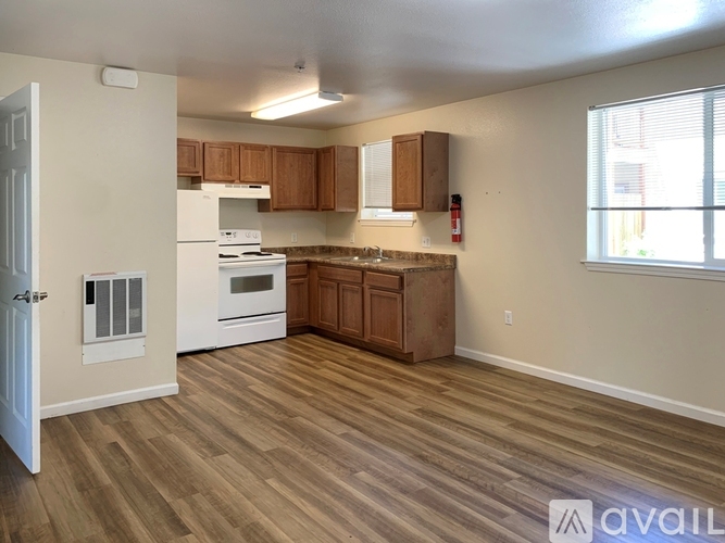 A kitchen with wooden floors and white appliances.